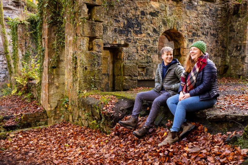 Couple at sitting on wall at old ruins site