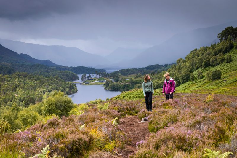 Couple walking on a hillside with loch in background