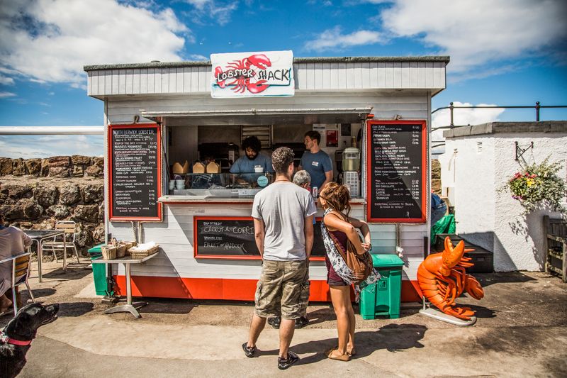 A couple waiting in line to make a purchase at a food van