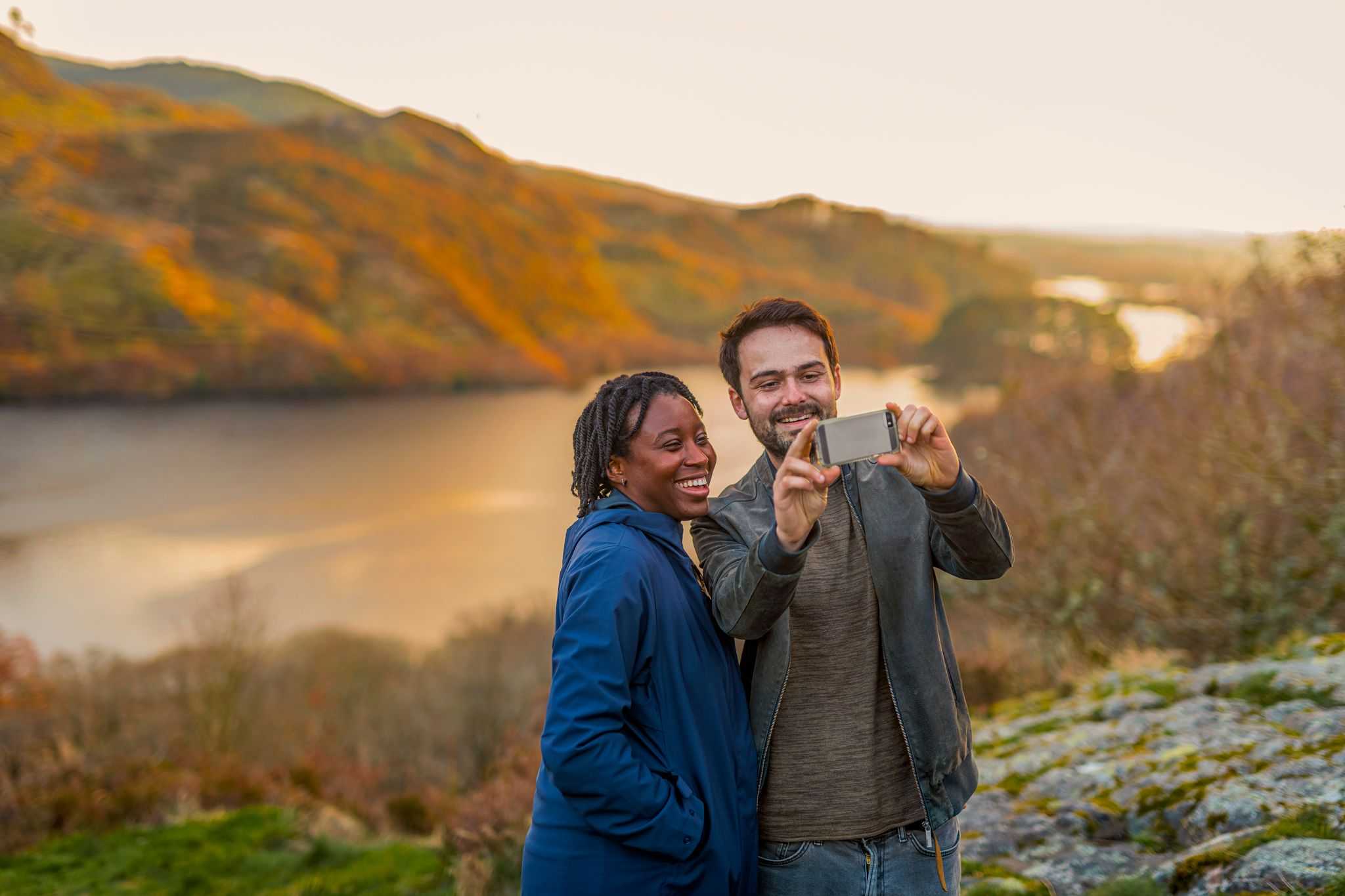 Couple taking selfie with river in background