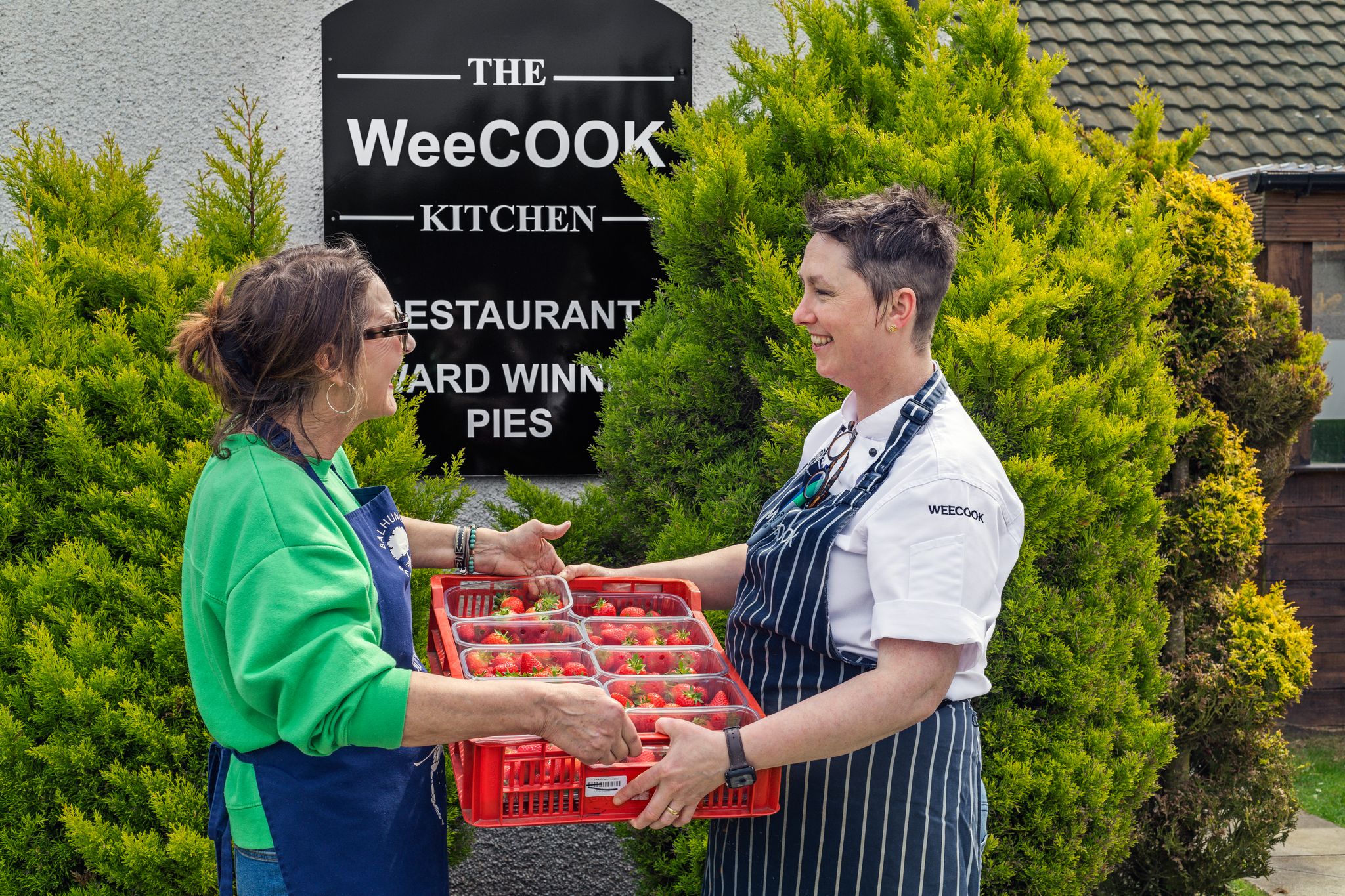 Cook receiving a tray of produce from supplier