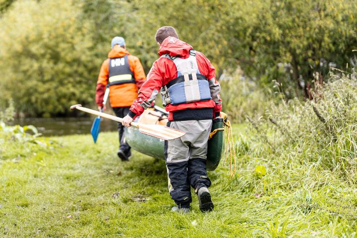 Vistors carrying canoe on Tweed Valley Canoe Trail