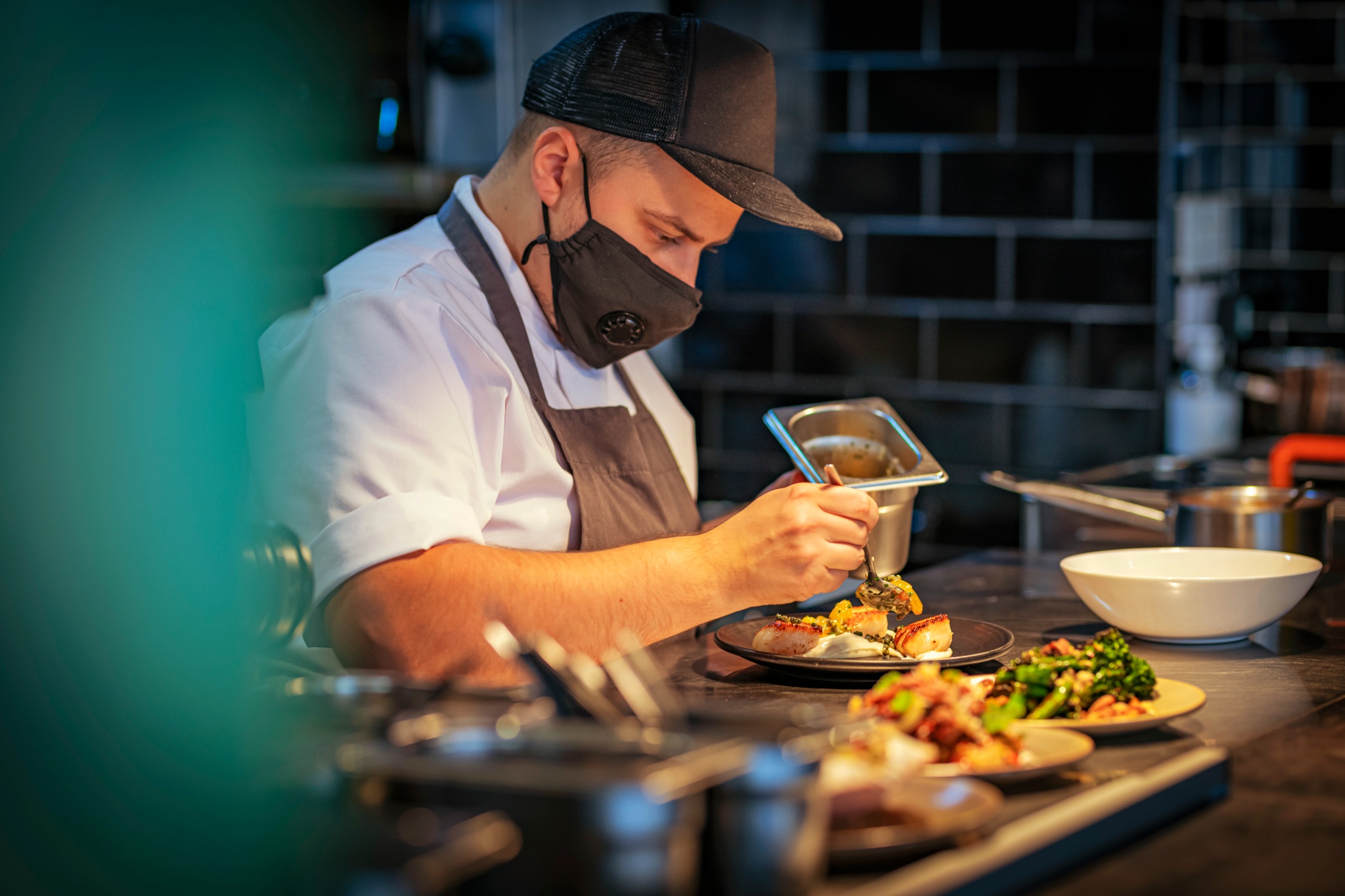 A chef adds finishing touches to dishes at Ox and Finch